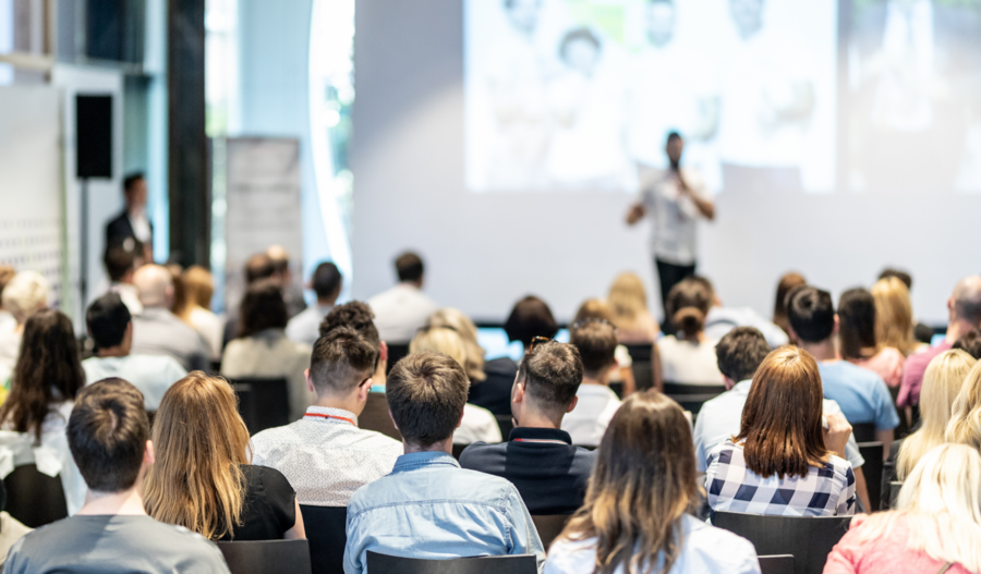 Crowd watching a speaker on stage.