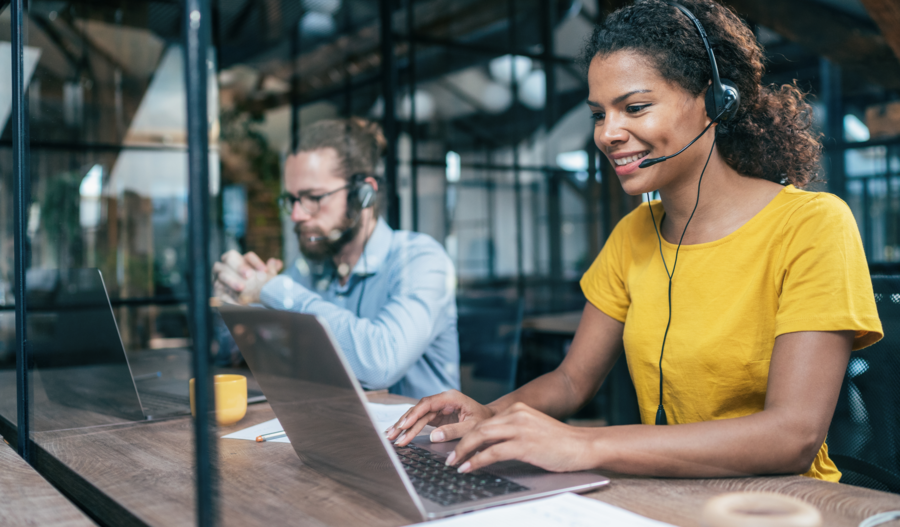 Woman smiling when working as support using a laptop.