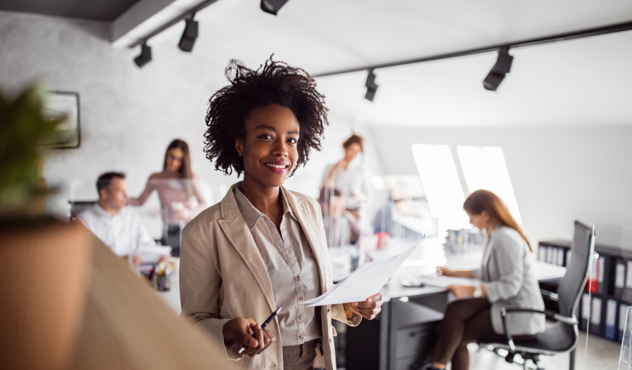 Woman smiling when holding pen and paper.